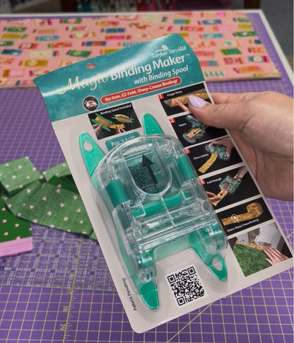 Magic Binding Maker with Binding Spool packaging held by a hand on a colorful background