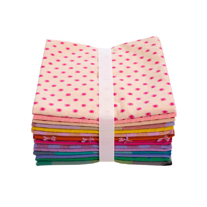 Stack of colorful fabric squares with a polka dot pattern on top, tied with a white ribbon against a white background.