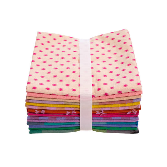 Stack of colorful fabric squares with a polka dot pattern on top, tied with a white ribbon against a white background.