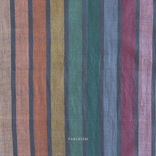Lucky Loom Wings in Dark Rainbow – reversible striped cotton fabric in jewel-toned rainbow palette with earthy hues, shown with soft folds to display texture