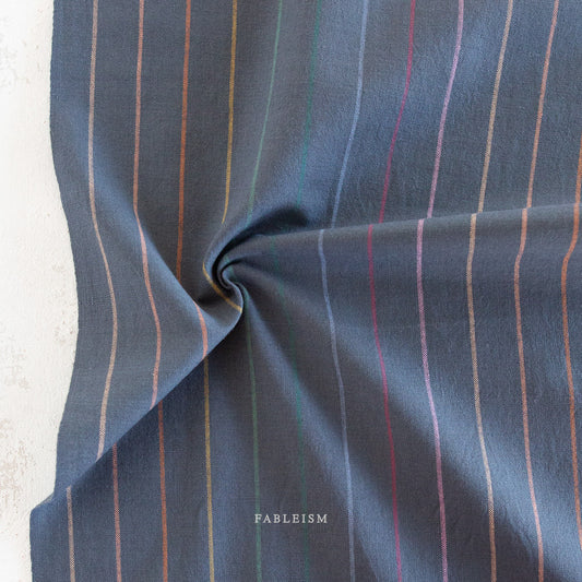 Lucky Loom Skinny Stripe in Dark Rainbow – navy base fabric with fine vertical rainbow pinstripes, shown flat to display color and weave
