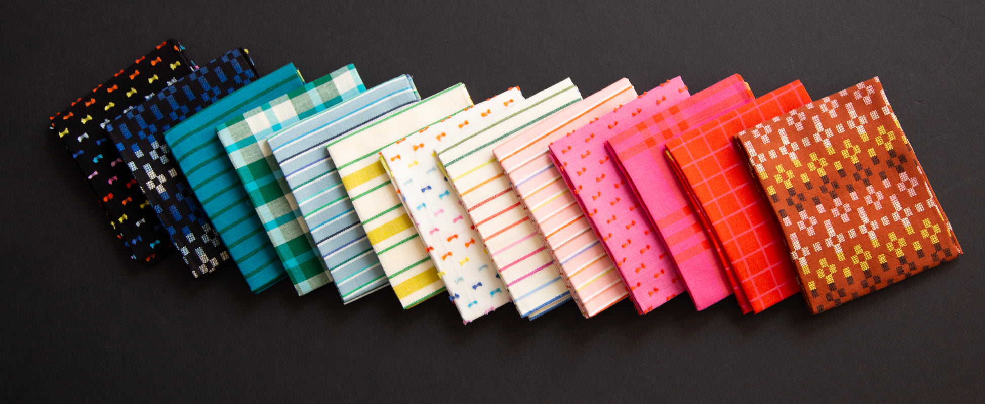 Row of colorful fabric swatches on a dark background ruby star mystic fable collection