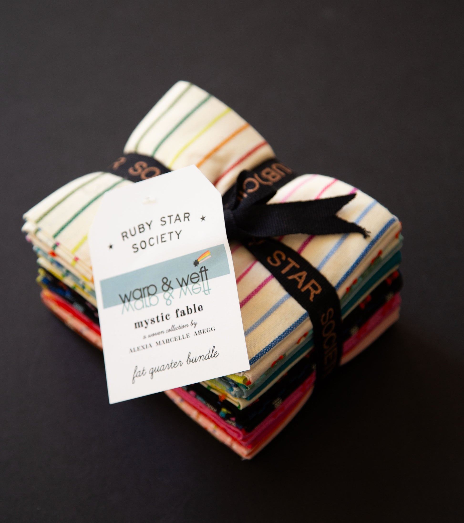 Stack of fabric bundles with a label on a dark background